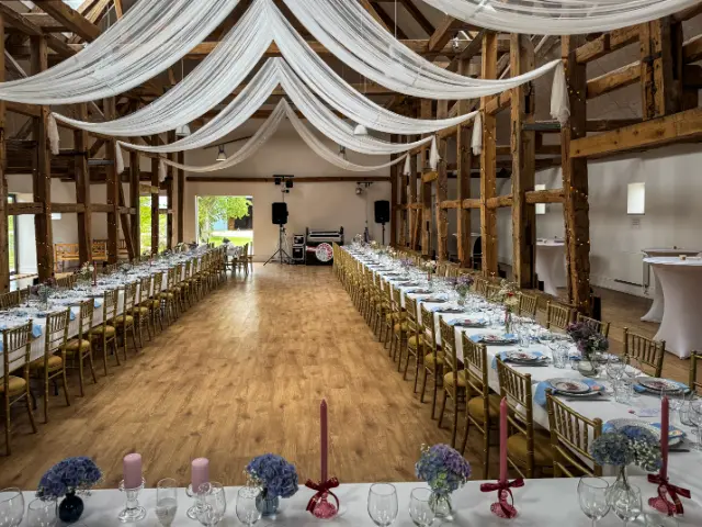 Erfaren bryllups-DJ fra Twiggi.dk spiller festmusik ved et elegant bryllupsarrangement. DJ’en står bag mixerpulten med professionelt udstyr, mens stemningsfuld LED-belysning oplyser dansegulvet, hvor glade gæster danser. Med over 50 års erfaring skaber Twiggi den perfekte musikalske ramme til bryllupsfester, hvor både brudevalsen og de nyeste hits får alle generationer på dansegulvet.